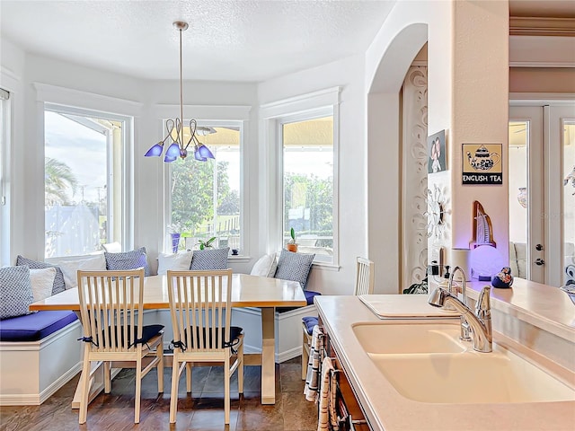 dining area featuring a chandelier, a textured ceiling, and sink