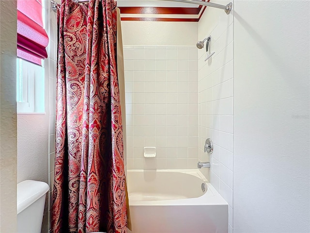 bathroom featuring shower / tub combo and toilet