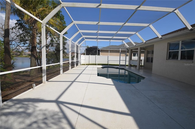 view of swimming pool with a patio, a water view, and glass enclosure