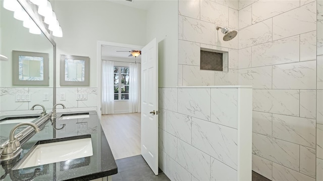 full bathroom with vanity, walk in shower, tile walls, and a ceiling fan