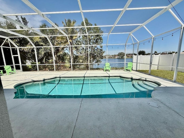 view of pool with glass enclosure, a patio area, a fenced in pool, and a water view