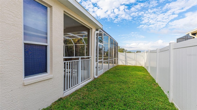 view of yard featuring glass enclosure and a fenced backyard