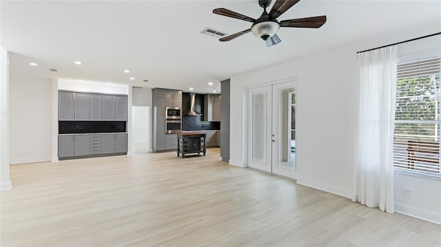 unfurnished living room with recessed lighting, visible vents, baseboards, french doors, and light wood finished floors