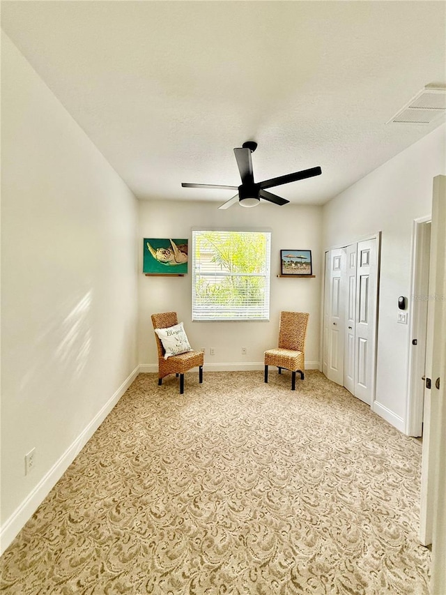 living area with a ceiling fan, carpet, visible vents, and baseboards