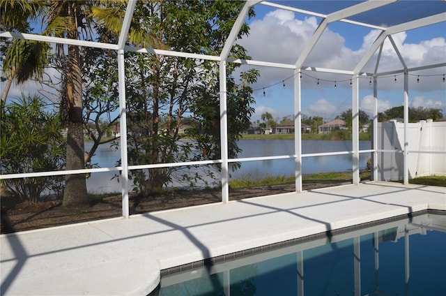 pool featuring a lanai, a water view, and a patio