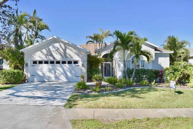 view of front facade featuring a garage, a front yard, driveway, and stucco siding