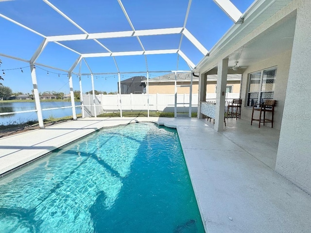 view of swimming pool with a fenced in pool, a water view, glass enclosure, a patio area, and fence