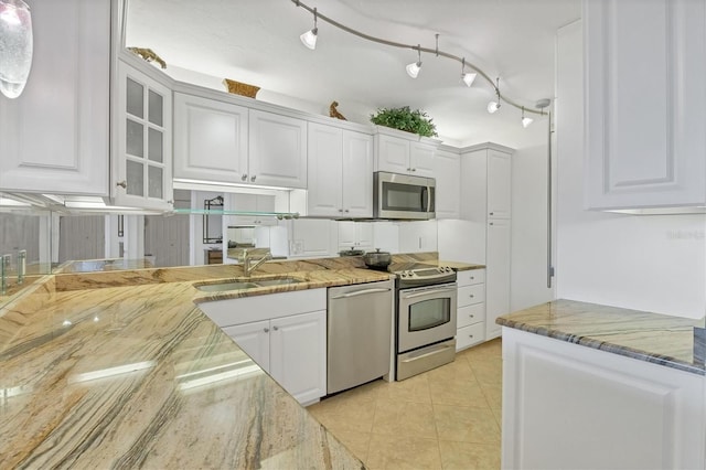 kitchen with light stone countertops, appliances with stainless steel finishes, and white cabinetry