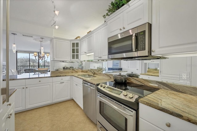 kitchen featuring appliances with stainless steel finishes, rail lighting, sink, a notable chandelier, and white cabinets