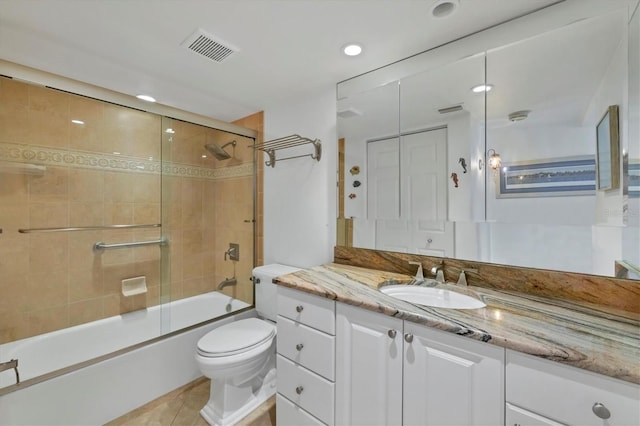 full bathroom featuring tile patterned floors, vanity, toilet, and combined bath / shower with glass door