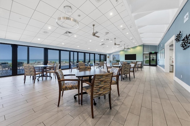 dining space featuring a water view and ceiling fan