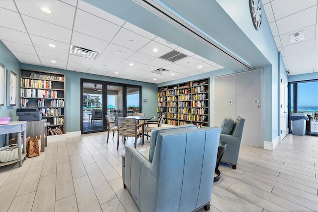 living room featuring built in shelves and a drop ceiling