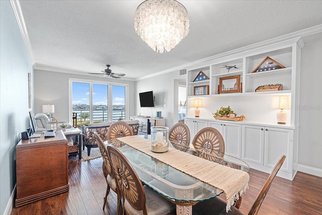 dining room with ceiling fan with notable chandelier, dark hardwood / wood-style flooring, a textured ceiling, and ornamental molding