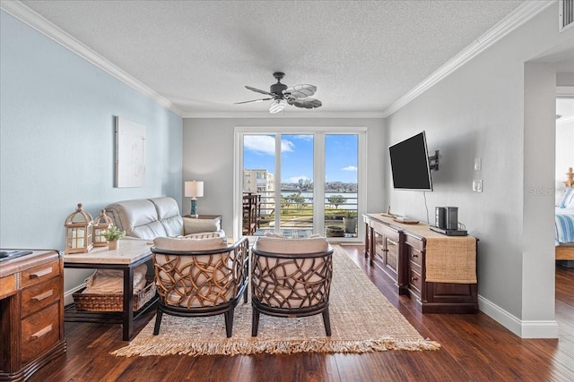 living room with ceiling fan, dark hardwood / wood-style flooring, ornamental molding, and a textured ceiling