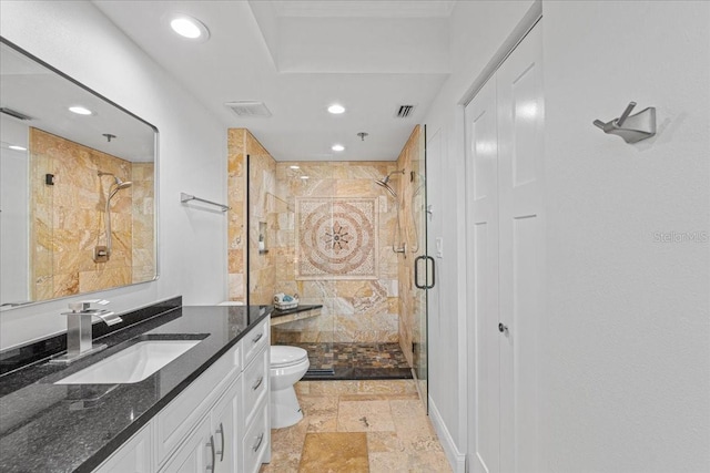 bathroom with a shower with door, vanity, and toilet