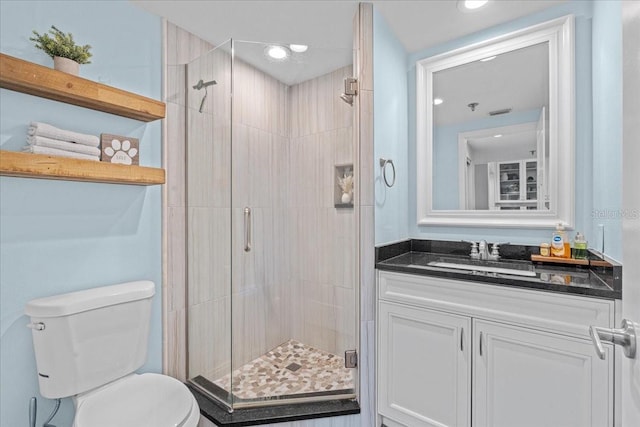 bathroom featuring an enclosed shower, vanity, and toilet