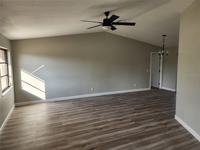 unfurnished room with a textured ceiling, ceiling fan with notable chandelier, dark wood-type flooring, and lofted ceiling