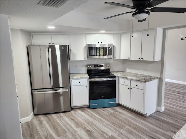 kitchen with ceiling fan, stainless steel appliances, light stone counters, light hardwood / wood-style flooring, and white cabinets