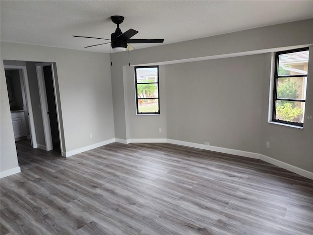 spare room featuring ceiling fan, wood-type flooring, and a textured ceiling