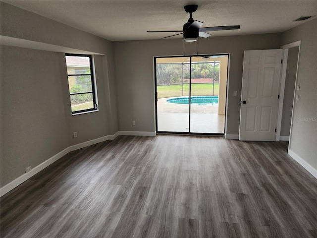 spare room featuring hardwood / wood-style floors, ceiling fan, and a healthy amount of sunlight