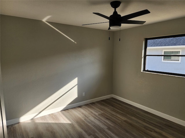 spare room with ceiling fan and dark wood-type flooring