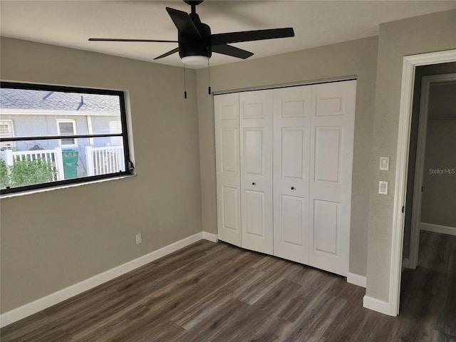 unfurnished bedroom featuring ceiling fan, dark hardwood / wood-style flooring, and a closet