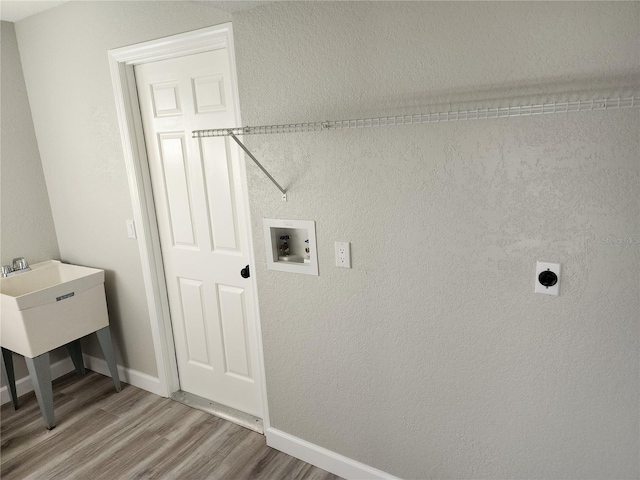 clothes washing area featuring hookup for an electric dryer, washer hookup, and wood-type flooring