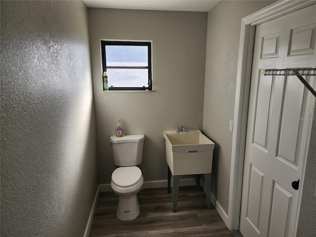 bathroom featuring toilet and wood-type flooring