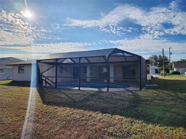 rear view of property featuring a lanai and a lawn