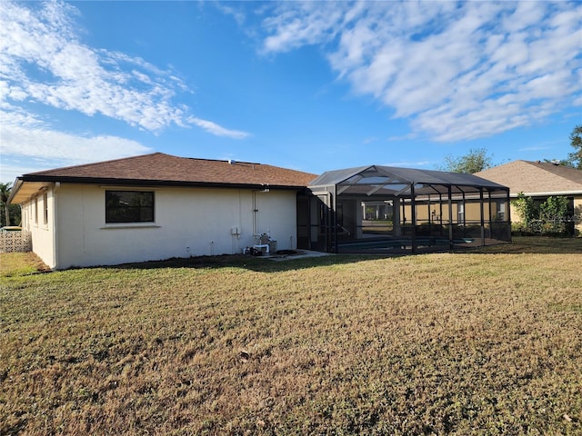 rear view of property with a lanai and a lawn