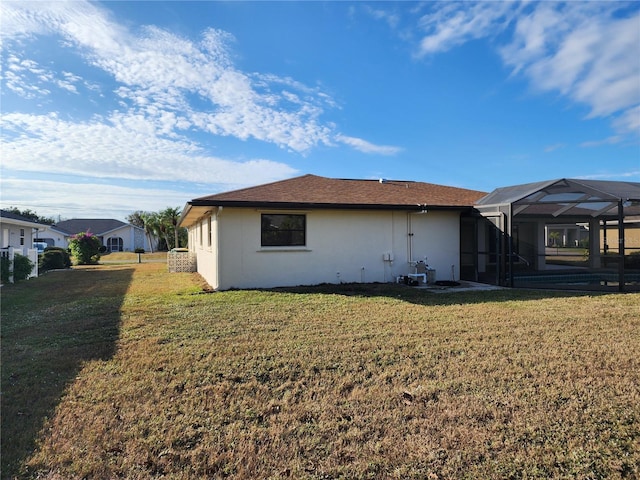 back of house with a lanai and a yard