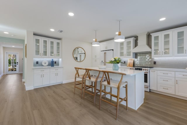 kitchen with pendant lighting, white cabinetry, white appliances, and custom range hood