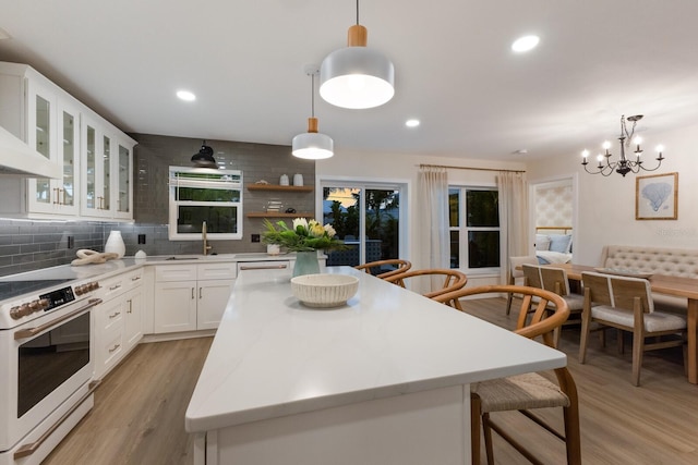 kitchen featuring decorative backsplash, white appliances, white cabinets, a chandelier, and hanging light fixtures