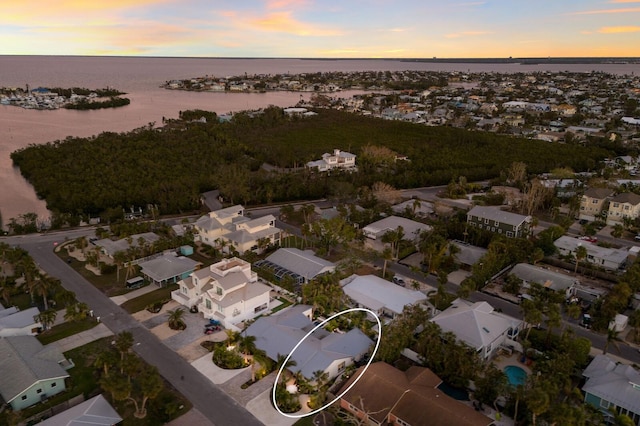 aerial view at dusk featuring a water view