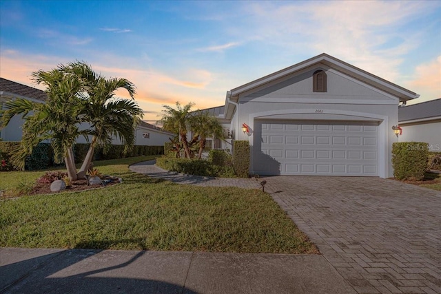 view of front of property with a yard and a garage