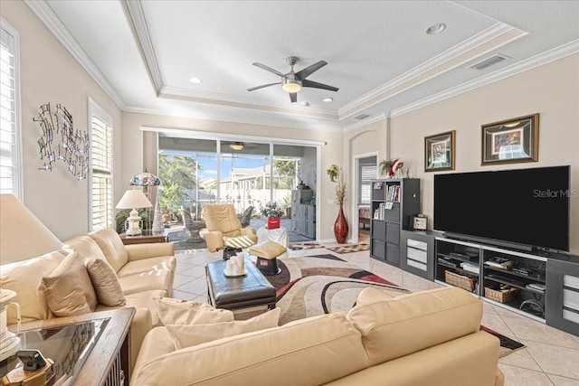 tiled living room with a tray ceiling, a wealth of natural light, and ornamental molding