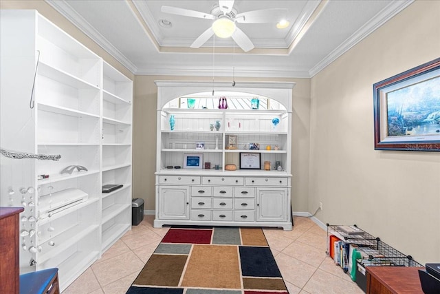 interior space with a raised ceiling, crown molding, and ceiling fan