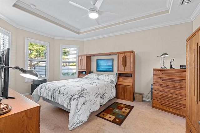 bedroom with ceiling fan, a raised ceiling, light carpet, and multiple windows