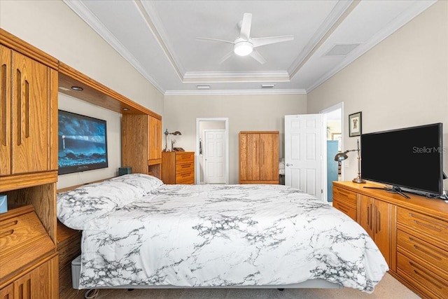 carpeted bedroom with a tray ceiling, ceiling fan, and ornamental molding