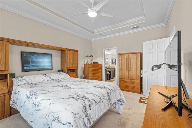 carpeted bedroom with ensuite bathroom, crown molding, ceiling fan, and a tray ceiling