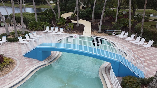 view of pool with a water view and a patio area