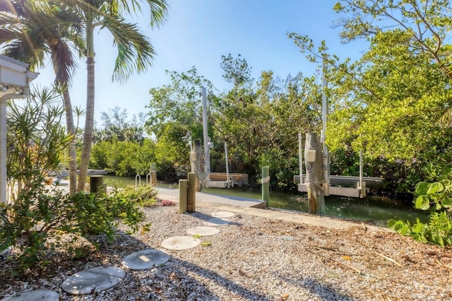 view of yard featuring a dock and a water view