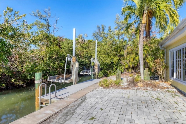 563 Juan Anasco Dr, Longboat Key, FL 34228 - view of home's community with a dock, a water view, a patio area, boat lift, and view of wooded area