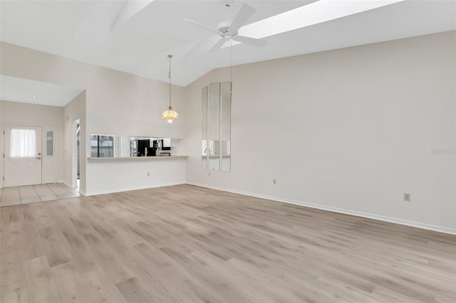 unfurnished living room featuring lofted ceiling, ceiling fan, and light wood-type flooring