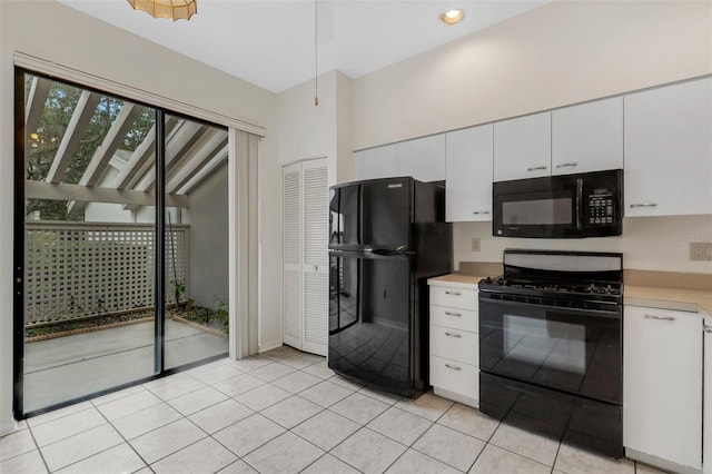 kitchen featuring light tile patterned flooring, white cabinetry, and black appliances