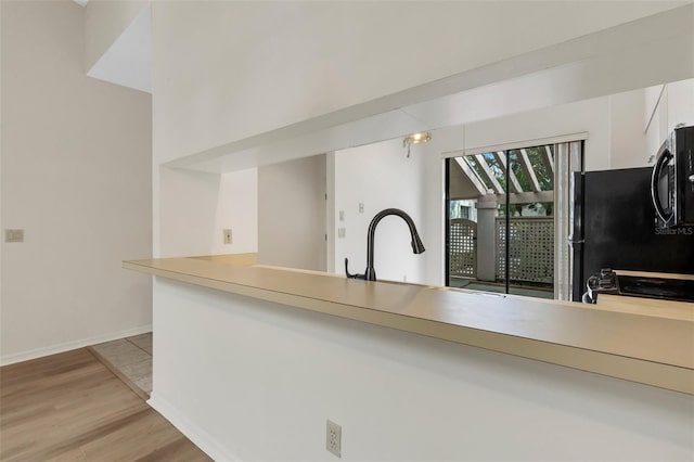 kitchen featuring white cabinets, light hardwood / wood-style floors, stove, and sink