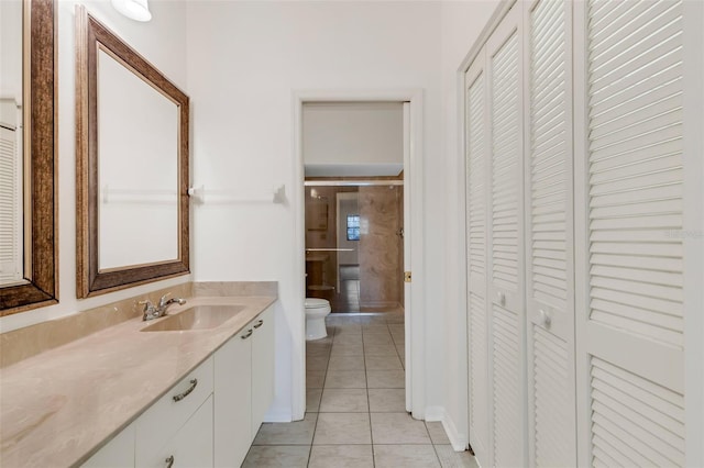 bathroom with toilet, vanity, and tile patterned floors