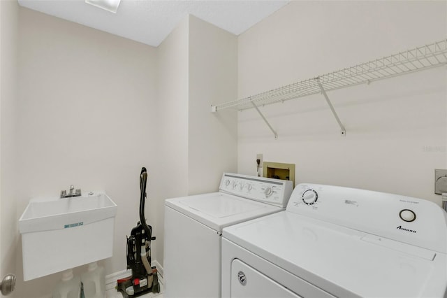 washroom with independent washer and dryer and sink