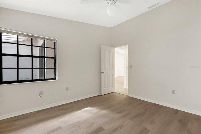 empty room with wood finished floors, visible vents, baseboards, and ceiling fan