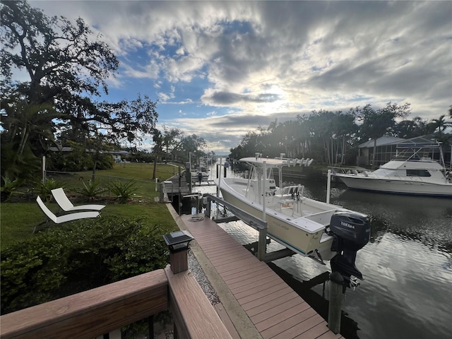 view of dock with a lawn, a water view, and boat lift